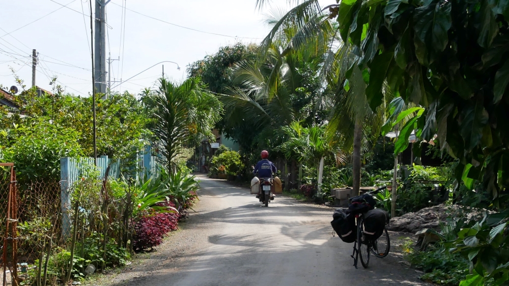 Bicycle with panniers on a quiet Mekong Delta back road - this region of Vietnam is flat and easy for cycling.