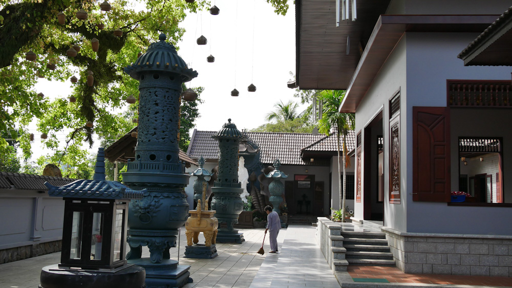 A nun sweeps the grounds at Phat Da pagoda. 