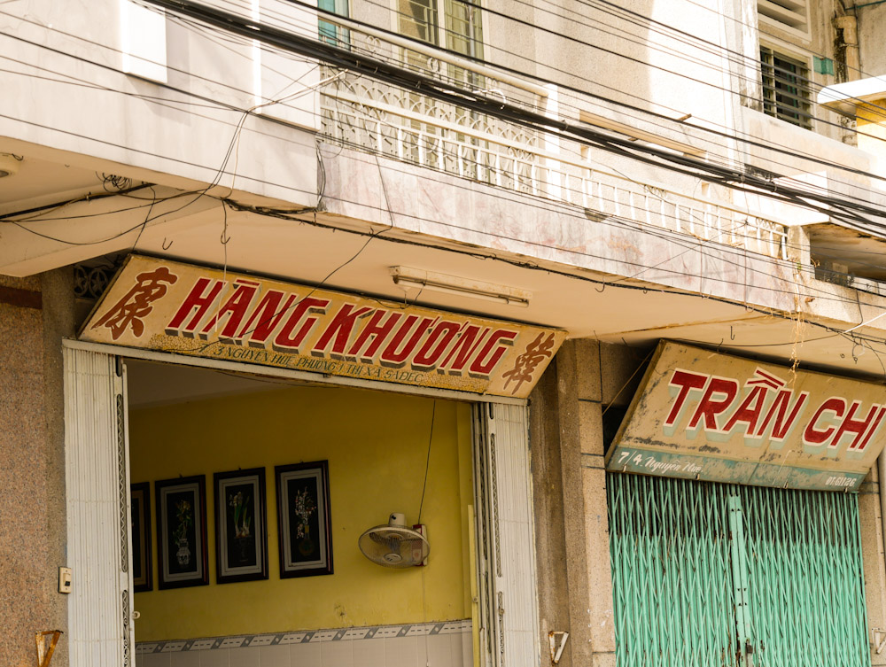 Faded shop houses on Sa Dec feature Chinese characters. 